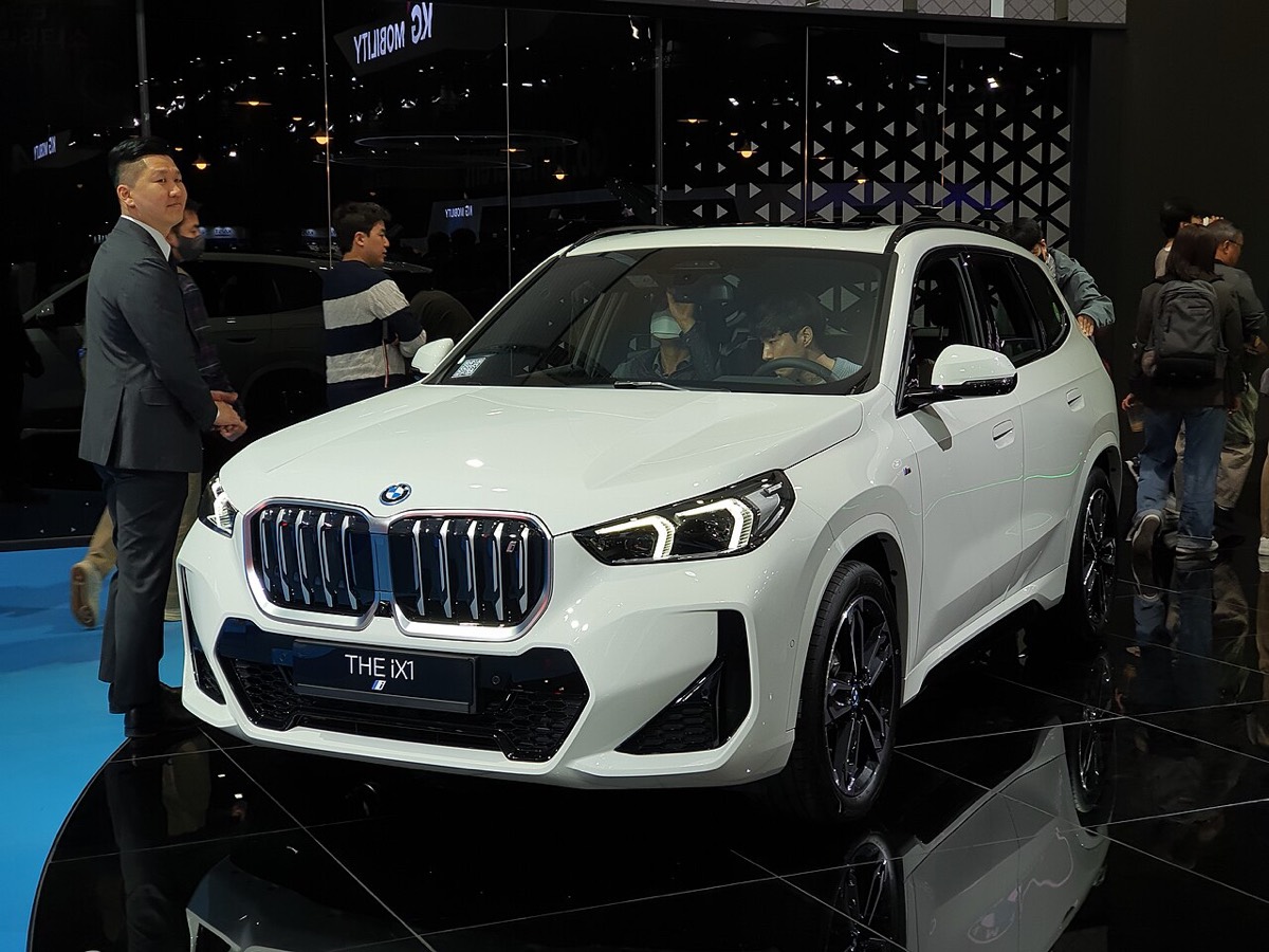 Weißer BMW iX1 xDrive30 auf einer Messebühne